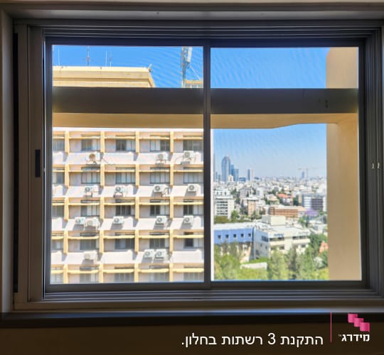 חלון אלומיניום עם נוף עירוני ברקע